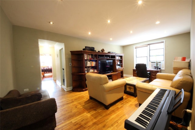 living area with light wood finished floors, baseboards, and recessed lighting