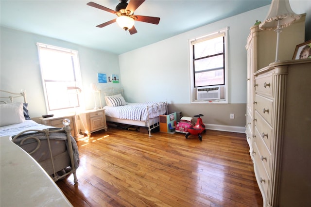 bedroom with ceiling fan, baseboards, cooling unit, and light wood-style floors