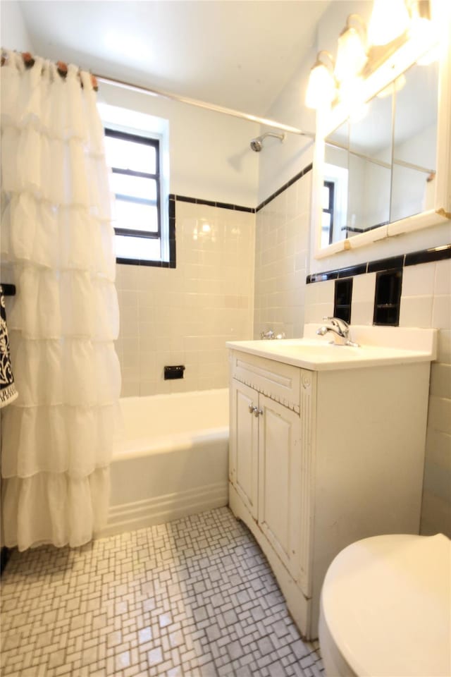 bathroom with toilet, shower / bath combo, vanity, and tile walls