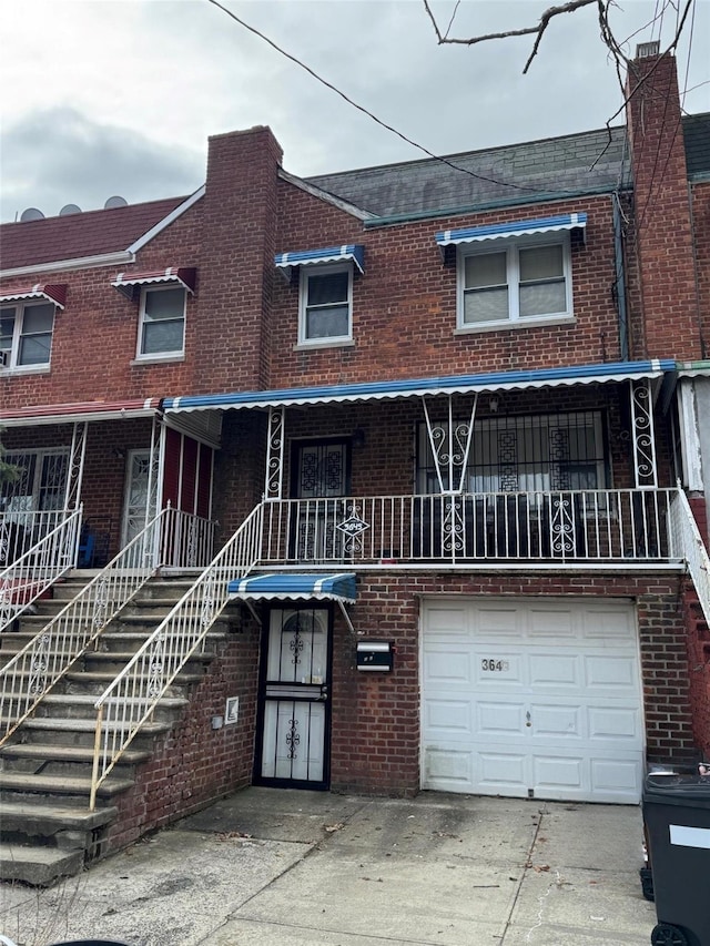 multi unit property with stairs, driveway, and brick siding