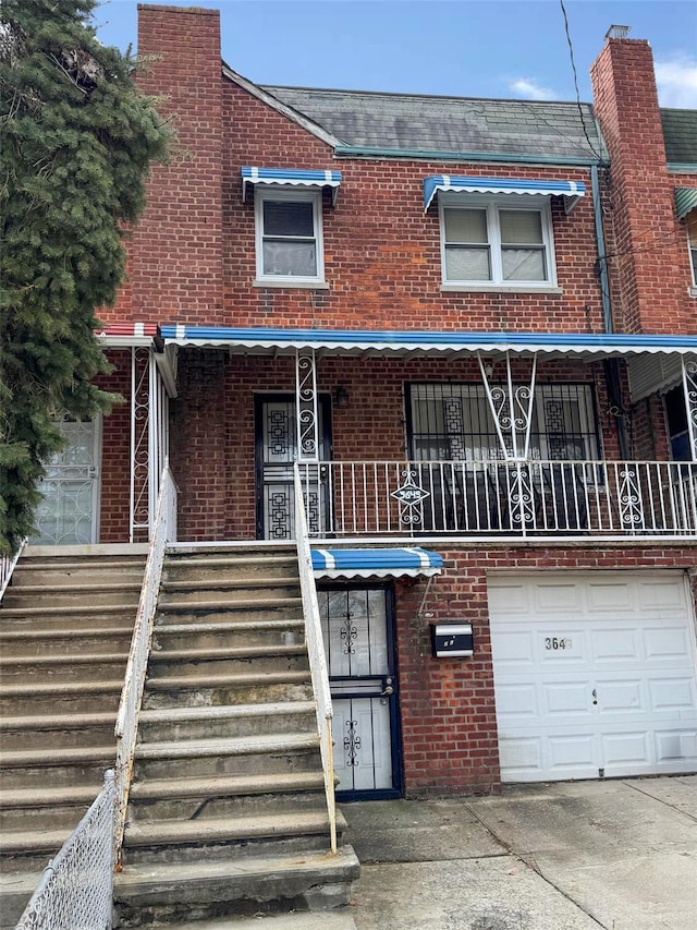 townhome / multi-family property featuring brick siding, driveway, and a garage