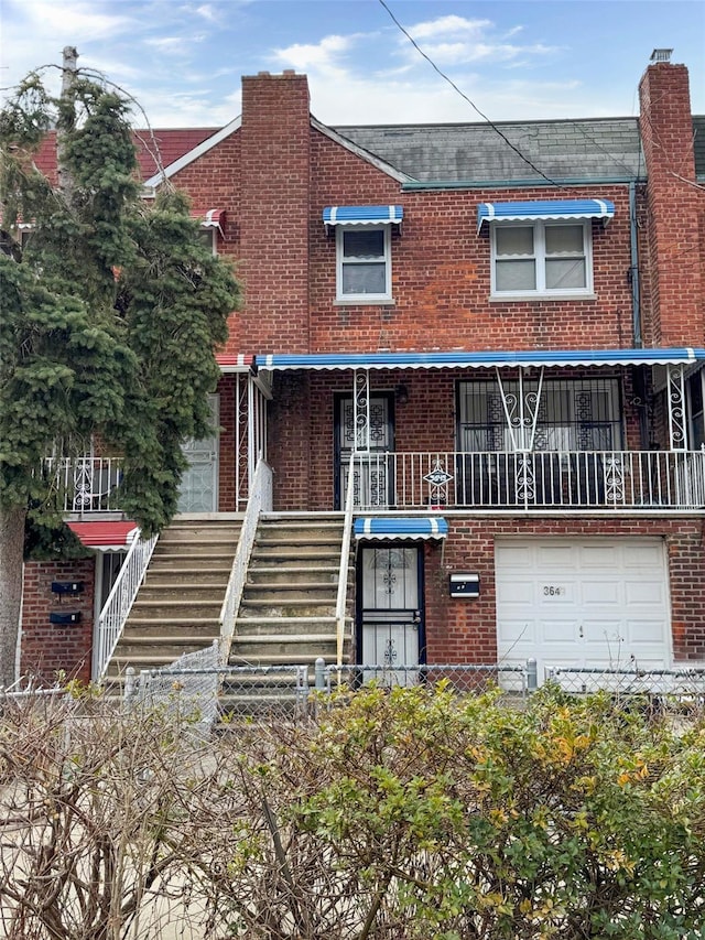 3645 Fenton Ave, Bronx, NY 10469 - view of property featuring stairs, a garage, brick siding, and a fenced front yard