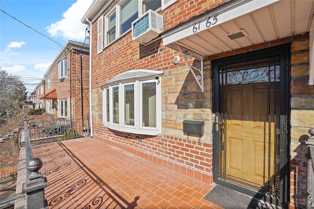 doorway to property with brick siding and cooling unit