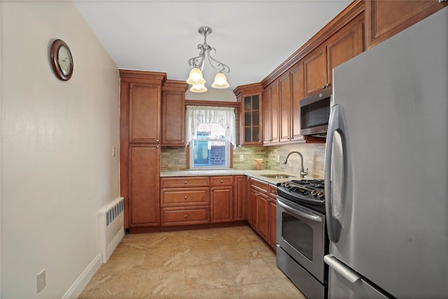 kitchen with brown cabinetry, radiator, stainless steel appliances, light countertops, and backsplash