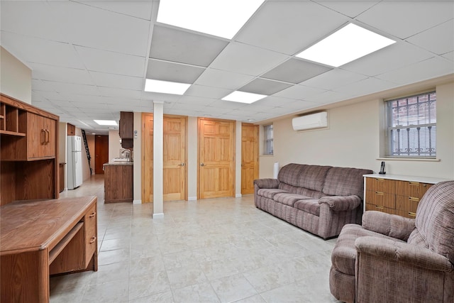 living room featuring a drop ceiling and a wall mounted AC