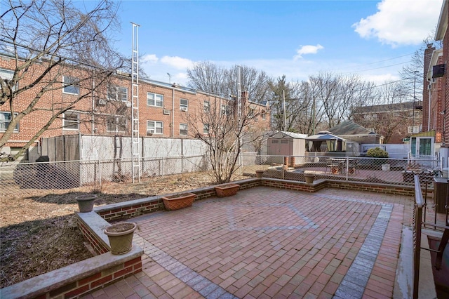 view of patio with a fenced backyard, a storage unit, and an outdoor structure