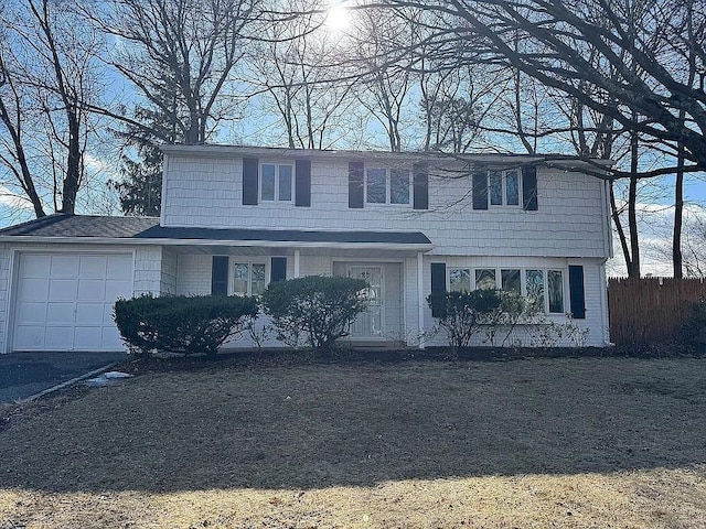 view of front of house with a garage, brick siding, fence, and aphalt driveway