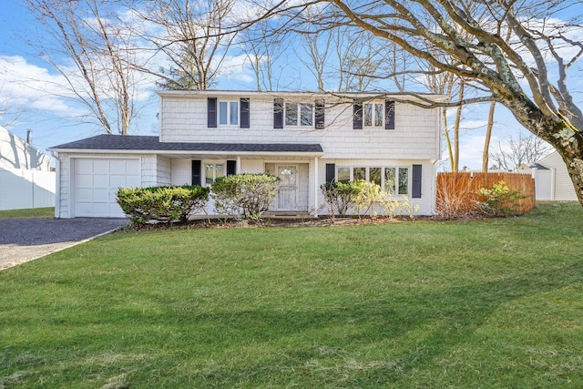 view of front facade featuring driveway, an attached garage, fence, and a front yard