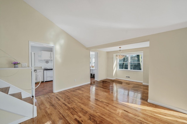 unfurnished living room with high vaulted ceiling, visible vents, light wood-style flooring, and baseboards