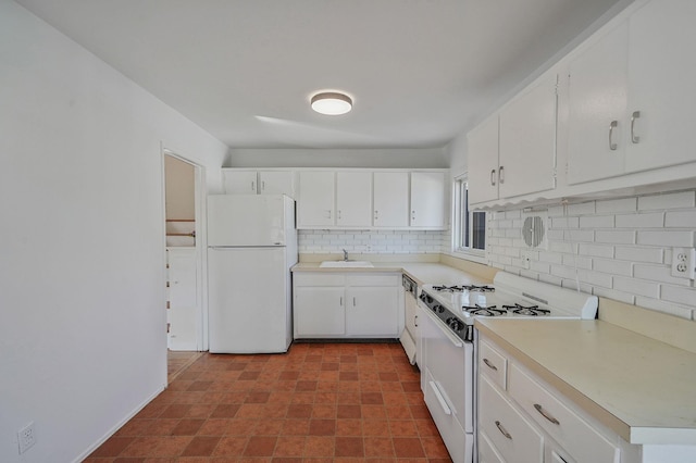 kitchen featuring light countertops, backsplash, white cabinetry, a sink, and white appliances