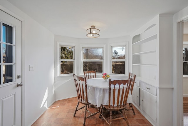 dining space featuring baseboards and built in features