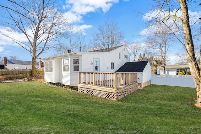 back of house featuring a yard, a chimney, a fenced backyard, and a wooden deck