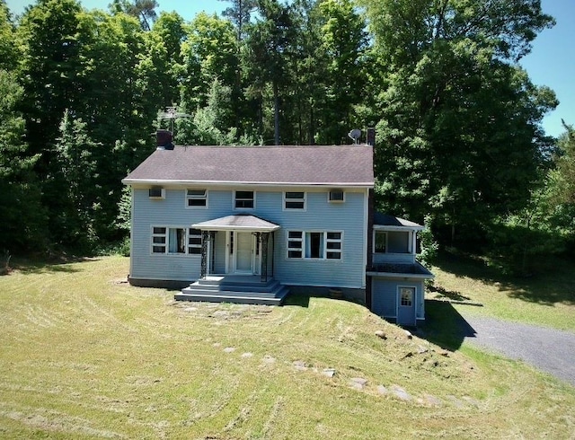 colonial-style house featuring a front yard