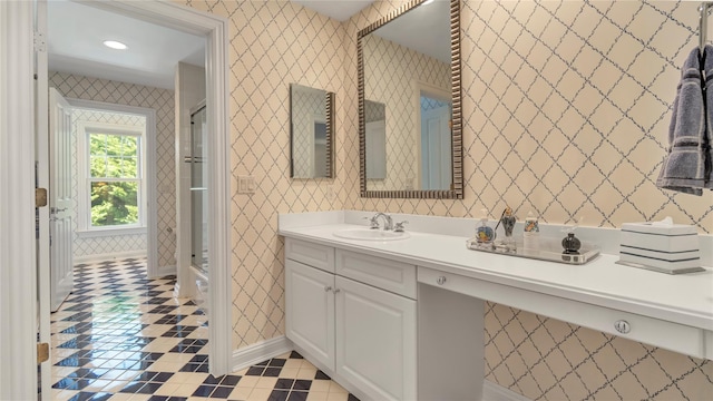 full bath with wallpapered walls, baseboards, vanity, and a stall shower