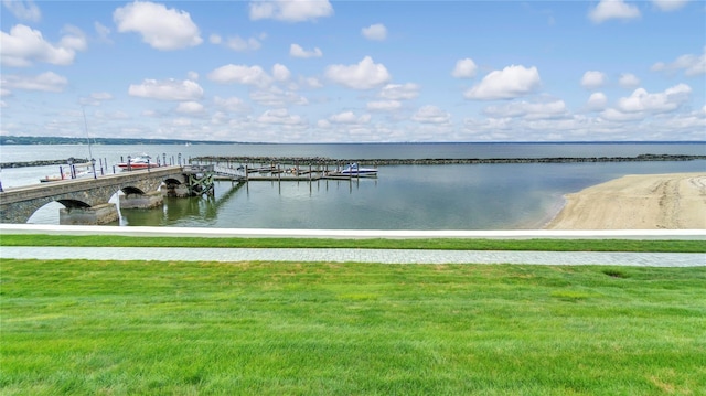 dock area with a lawn and a water view
