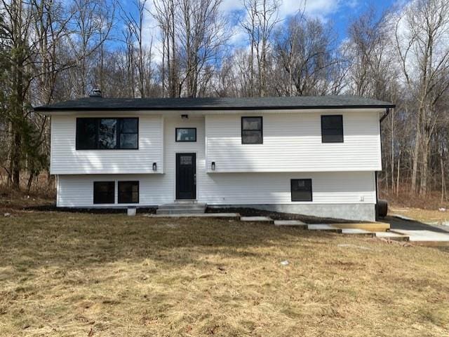 bi-level home featuring entry steps and a front lawn