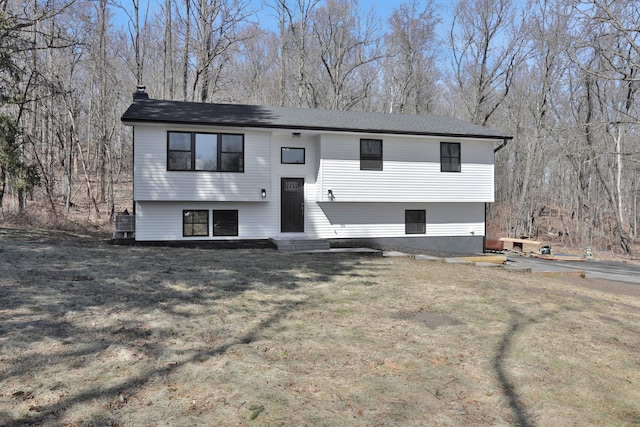 bi-level home with a front lawn and entry steps