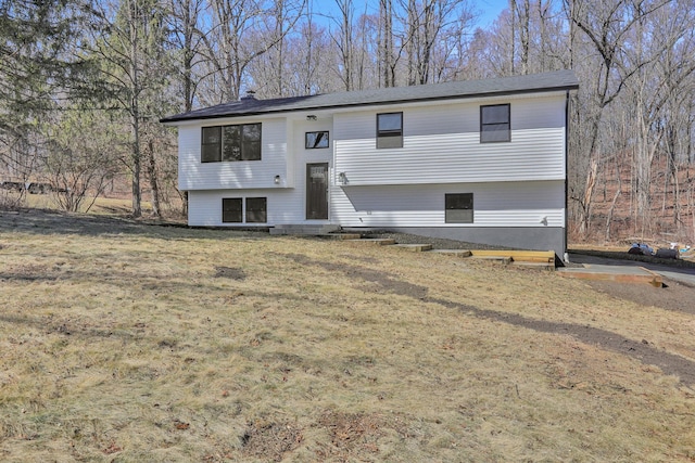 raised ranch with entry steps and a front lawn