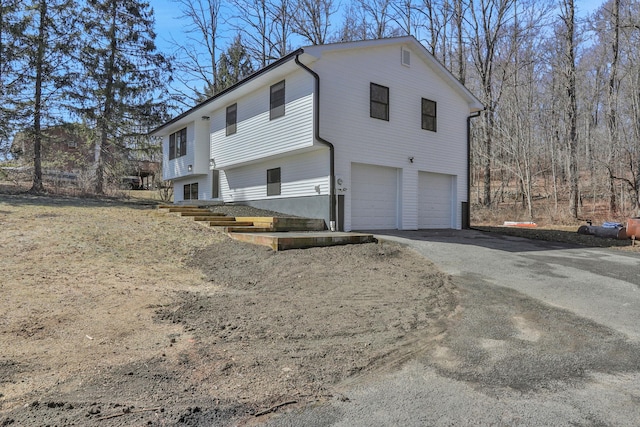 view of side of property with a garage and driveway