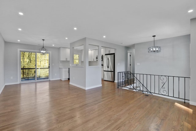 interior space featuring a notable chandelier, wood finished floors, recessed lighting, and baseboards