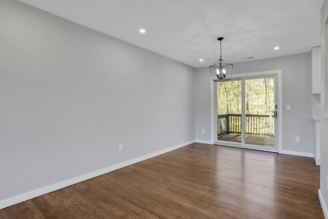 unfurnished room featuring dark wood finished floors, a notable chandelier, recessed lighting, and baseboards