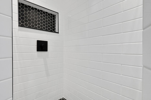 interior details featuring a tile shower