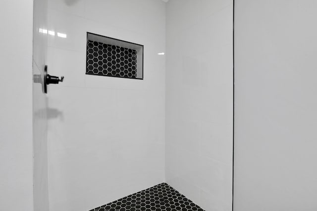 interior details with a tile shower