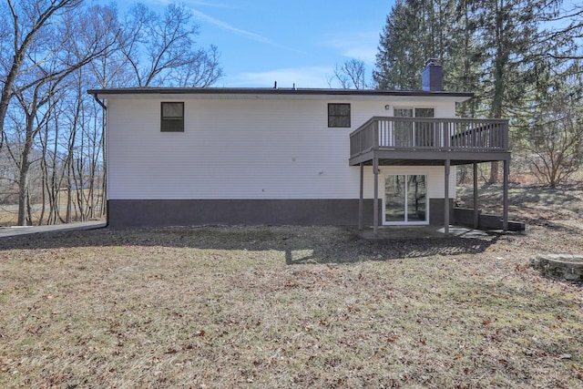 back of house with a chimney and a wooden deck