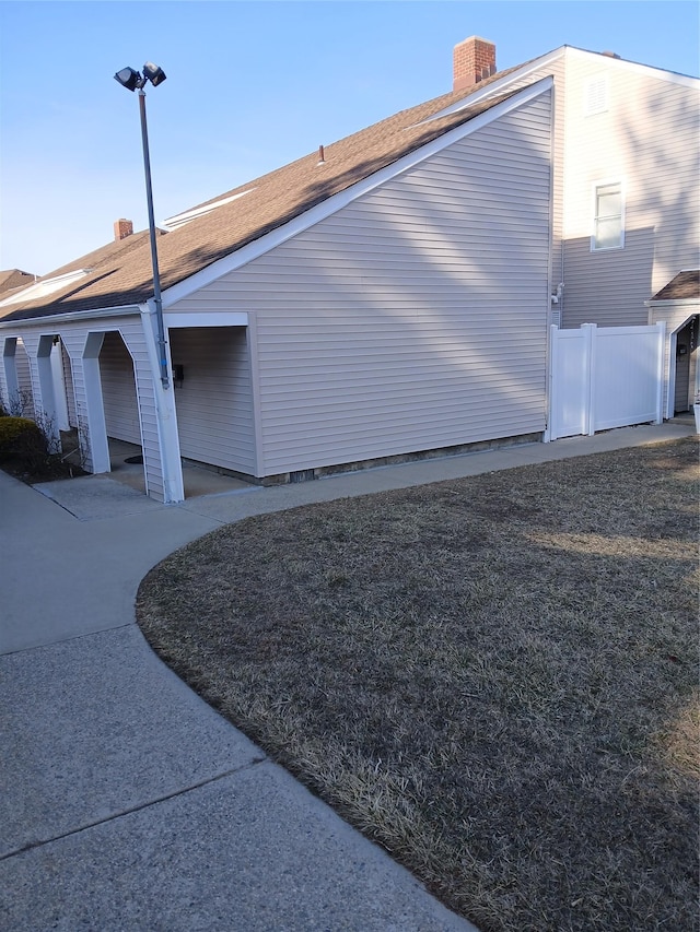 view of home's exterior featuring a chimney and fence