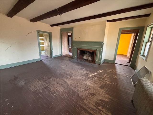 unfurnished living room with beam ceiling, a fireplace with flush hearth, wood finished floors, and baseboards