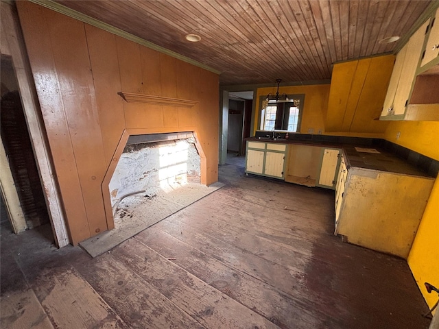 kitchen featuring a peninsula, a sink, hanging light fixtures, dark countertops, and wooden ceiling