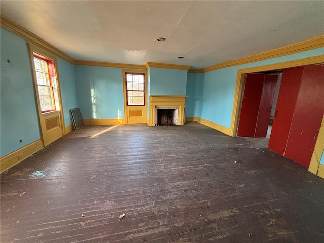 unfurnished living room with wood finished floors, a fireplace, baseboards, and ornamental molding