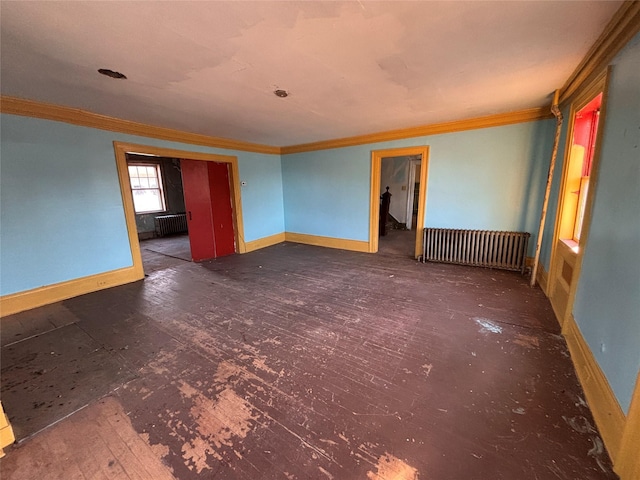 empty room with crown molding and radiator