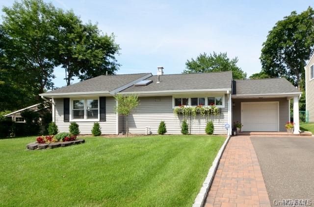 ranch-style home with an attached garage, driveway, and a front lawn