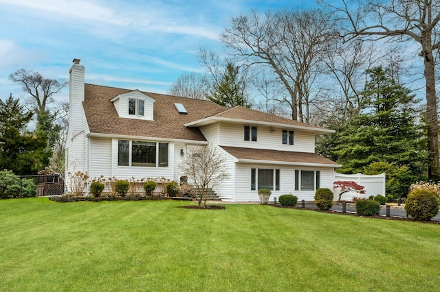 view of front of house featuring a shingled roof, a front yard, fence, and a chimney