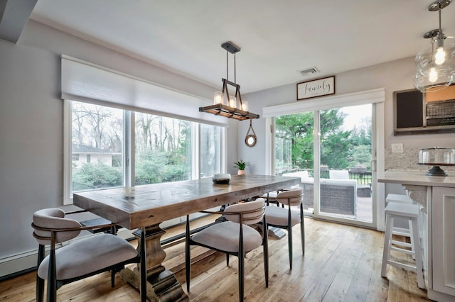 dining area featuring light wood-style flooring and visible vents