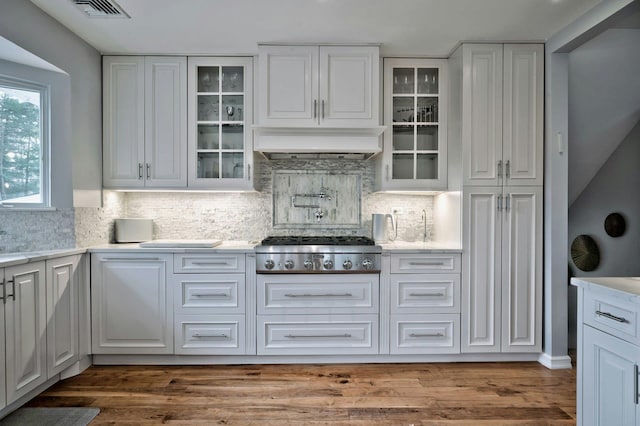 kitchen with light countertops, stainless steel gas stovetop, and white cabinetry