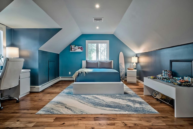 bedroom with a baseboard heating unit, wood finished floors, visible vents, and lofted ceiling