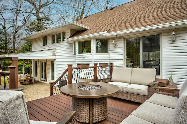 wooden deck featuring an outdoor living space with a fire pit