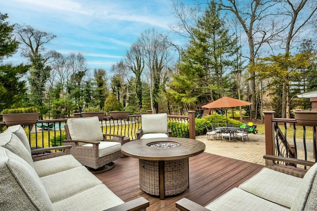 wooden terrace with outdoor dining area and an outdoor living space with a fire pit