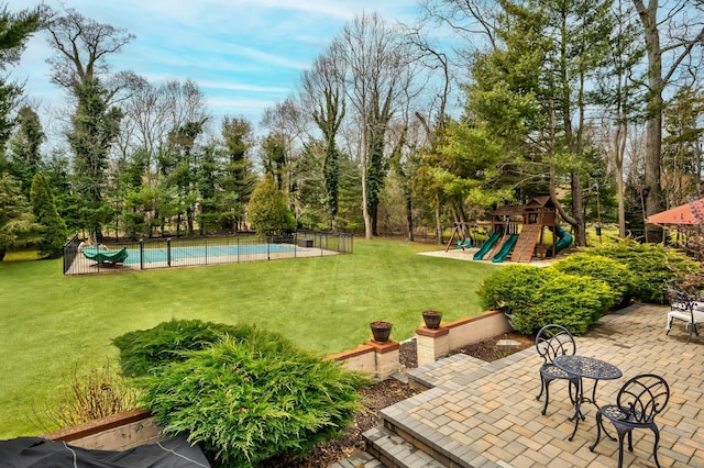 view of yard featuring a fenced in pool, playground community, a patio, and fence