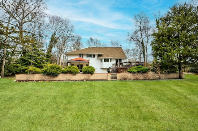 back of house featuring a lawn and a wooden deck