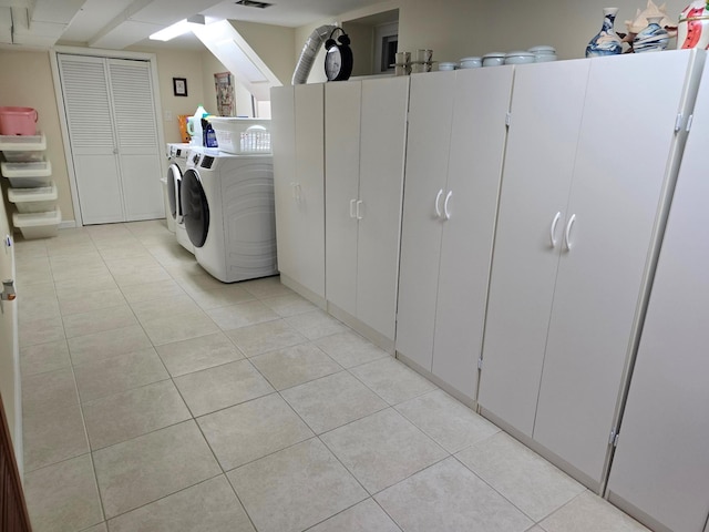 washroom featuring light tile patterned floors, washing machine and clothes dryer, and visible vents