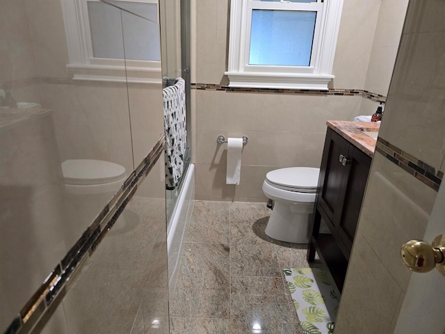 full bath featuring toilet, shower / bathing tub combination, tile walls, and vanity