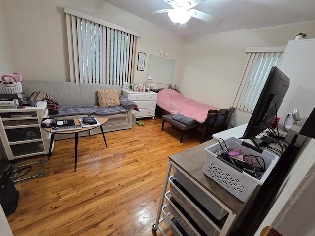 bedroom featuring light wood-type flooring, a ceiling fan, and crown molding