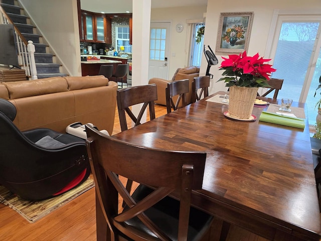 dining space featuring stairs and light wood-style flooring