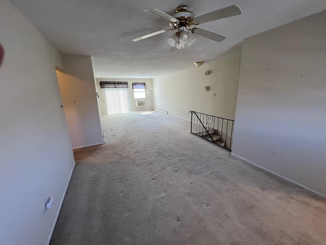 spare room featuring ceiling fan, baseboards, and carpet