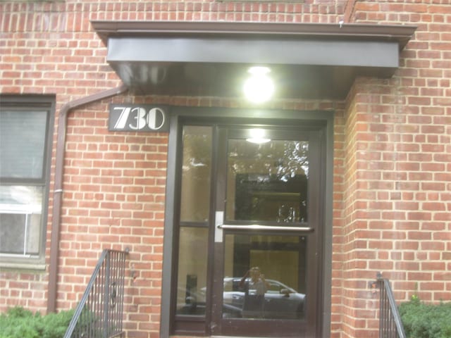 entrance to property featuring brick siding