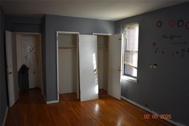 unfurnished bedroom with baseboards and wood finished floors