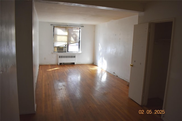 unfurnished room with hardwood / wood-style flooring and radiator